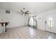 Light-filled living room with tiled floors, ceiling fan, and entry door at 25449 Doredo Dr, Punta Gorda, FL 33955