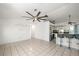 Open-concept living space with white tile floors, ceiling fan, and kitchen with breakfast bar at 25449 Doredo Dr, Punta Gorda, FL 33955