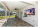 Covered patio with brick flooring, ceiling fan, and outdoor TV for entertainment at 25449 Doredo Dr, Punta Gorda, FL 33955