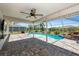 Covered patio area with a fan overlooking the screened pool, perfect for outdoor relaxation and entertaining at 25449 Doredo Dr, Punta Gorda, FL 33955