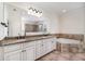 Spa-like bathroom with a large soaking tub, dual vanities, granite countertops, and a glass-enclosed shower at 2707 Auburn Blvd, Port Charlotte, FL 33948
