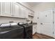 Well-equipped laundry room with granite counters, cabinets, sink, and modern washer and dryer at 2707 Auburn Blvd, Port Charlotte, FL 33948