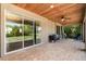Relaxing outdoor patio with brick flooring, ceiling fan, and sliding glass doors overlooking backyard at 2707 Auburn Blvd, Port Charlotte, FL 33948
