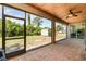 Spacious screened-in porch with ceiling fan, brick flooring, and tranquil backyard views at 2707 Auburn Blvd, Port Charlotte, FL 33948