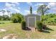Backyard shot featuring a storage shed with a ramp and lush green landscaping at 2707 Auburn Blvd, Port Charlotte, FL 33948