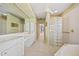 Bathroom featuring dual sinks, vanity area, glass block shower and tub with gold fixtures at 2719 Mayaguana Ct, Punta Gorda, FL 33950