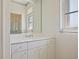 Bathroom featuring single sink vanity with a large mirror and wallpapered walls and decorative lighting at 2719 Mayaguana Ct, Punta Gorda, FL 33950