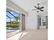 Bedroom featuring light carpet, ceiling fan and large glass doors leading to the screened-in pool at 2719 Mayaguana Ct, Punta Gorda, FL 33950
