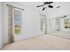 Bright bedroom featuring neutral carpet, closet with mirrored doors, two windows and ceiling fan at 2719 Mayaguana Ct, Punta Gorda, FL 33950