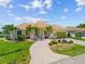 Well maintained single-Gathering home featuring a tile roof, paver driveway, lush lawn, and tropical landscaping at 2719 Mayaguana Ct, Punta Gorda, FL 33950