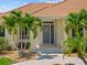 Inviting front entrance with a secure screen door, complemented by tropical palm trees and manicured landscaping at 2719 Mayaguana Ct, Punta Gorda, FL 33950