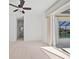 Spacious room with carpeting, ceiling fan, and glass doors leading to a screened pool area at 2719 Mayaguana Ct, Punta Gorda, FL 33950