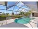 Backyard screened-in pool features clear blue water and a spa with canal views and beautiful landscaping at 2719 Mayaguana Ct, Punta Gorda, FL 33950