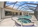 Enclosed pool and spa area with a tiled deck, seating and view into the living space at 2719 Mayaguana Ct, Punta Gorda, FL 33950