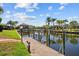 Scenic canal view with a private dock, boat lift, lush landscaping, and clear blue skies at 2719 Mayaguana Ct, Punta Gorda, FL 33950