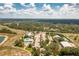 Aerial view of the community's recreational center featuring a pool, parking area, and surrounded by lush greenery at 2913 Royal Palm Dr, North Port, FL 34288