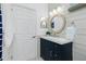 Charming bathroom with a navy vanity, round mirror, and shiplap accent wall at 2913 Royal Palm Dr, North Port, FL 34288