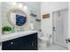 Nautical bathroom with stylish vanity, round mirror, beach decor, and good lighting at 2913 Royal Palm Dr, North Port, FL 34288