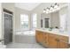 Well-lit bathroom featuring dual sinks, a soaking tub, and a glass-enclosed shower at 2913 Royal Palm Dr, North Port, FL 34288