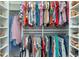 Organized walk-in closet with clothes hanging on rods and shoes neatly arranged on shelves at 2913 Royal Palm Dr, North Port, FL 34288