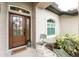 Inviting front entryway with a decorative wreath, quaint seating, and a 'Welcome' mat at 2913 Royal Palm Dr, North Port, FL 34288