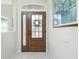 Inviting entryway showcasing a wood front door with glass panes, sidelight and transom window at 2913 Royal Palm Dr, North Port, FL 34288