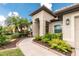 Beautiful beige home with lush landscaping, a welcoming entryway, and a meticulously maintained lawn at 2913 Royal Palm Dr, North Port, FL 34288