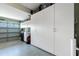 Clean garage with ample storage featuring custom white cabinets and epoxy flooring at 2913 Royal Palm Dr, North Port, FL 34288