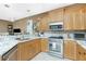 Bright kitchen featuring stainless steel appliances, granite countertops and light wood cabinetry at 2913 Royal Palm Dr, North Port, FL 34288
