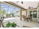 Spacious screened-in patio with lounge furniture, dining set, grill, and lush greenery at 2913 Royal Palm Dr, North Port, FL 34288