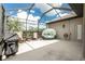 Relaxing screened-in patio with cozy seating, BBQ grill, and view of the landscape at 2913 Royal Palm Dr, North Port, FL 34288