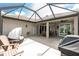 Large screened-in patio with multiple seating areas, grill, and view of lush greenery at 2913 Royal Palm Dr, North Port, FL 34288