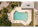 Aerial shot of a bright blue community pool surrounded by lounge chairs and tables, ideal for relaxation and entertainment at 2913 Royal Palm Dr, North Port, FL 34288