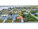 Aerial view of a waterfront home with a red roof, lush landscaping, and canal access at 3058 Curry Ter, Port Charlotte, FL 33981
