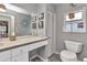 Well-lit bathroom featuring a vanity, large mirror, and a toilet with a window view at 3058 Curry Ter, Port Charlotte, FL 33981