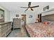 Cozy bedroom featuring a ceiling fan, patterned bedding, and access to a bathroom at 3058 Curry Ter, Port Charlotte, FL 33981