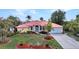 Charming single-Gathering home with a red roof, well-kept lawn, and tropical landscaping at 3058 Curry Ter, Port Charlotte, FL 33981