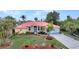 Charming single-Gathering home with a red roof, well-kept lawn, and tropical landscaping at 3058 Curry Ter, Port Charlotte, FL 33981