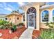 Close-up of the front entrance with decorative door, arched windows and mulch landscaping at 3058 Curry Ter, Port Charlotte, FL 33981