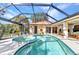 Enclosed pool and spa with clear blue skies, lush landscaping, and multiple access points from the home at 3058 Curry Ter, Port Charlotte, FL 33981