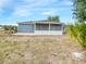 Back view of home with a screened in lanai and mature plants and landscaping at 3342 Avanti Cir, North Port, FL 34287