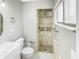 Bathroom with tiled shower, modern fixtures, tiled walls, new toilet, and bright lighting at 3342 Avanti Cir, North Port, FL 34287