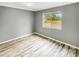 Bedroom features wood-look flooring, window view, and neutral-colored walls at 3342 Avanti Cir, North Port, FL 34287