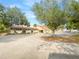 A commercial building situated behind trees with a parking lot at 3342 Avanti Cir, North Port, FL 34287