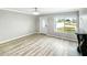 Bright living room with laminate floors, a decorative fireplace, and a large window offering a pleasant street view at 3342 Avanti Cir, North Port, FL 34287