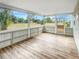 Sunroom with wood-look flooring and views of the backyard and neighboring community at 3342 Avanti Cir, North Port, FL 34287