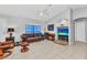 Comfortable living room features a leather sofa, tiled floor, and a ceiling fan for a cozy atmosphere at 3647 Culpepper Ter, North Port, FL 34286