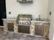 Well-equipped outdoor kitchen with stainless steel grill and stone accents at 432 Gun Cay Ln, Punta Gorda, FL 33950