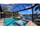 Relaxing screened-in pool and spa overlooking serene canal with dock and lift at 432 Gun Cay Ln, Punta Gorda, FL 33950
