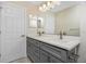 Bathroom vanity featuring double sinks, quartz counters, grey cabinets and modern fixtures at 4754 Caputo Ave, North Port, FL 34288